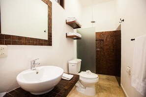 A bathroom with a large white sink, a toilet, a shower area, and a mirror. - Charming Private Retreat sleeps 6 with ocean views! (Isla Mujeres)