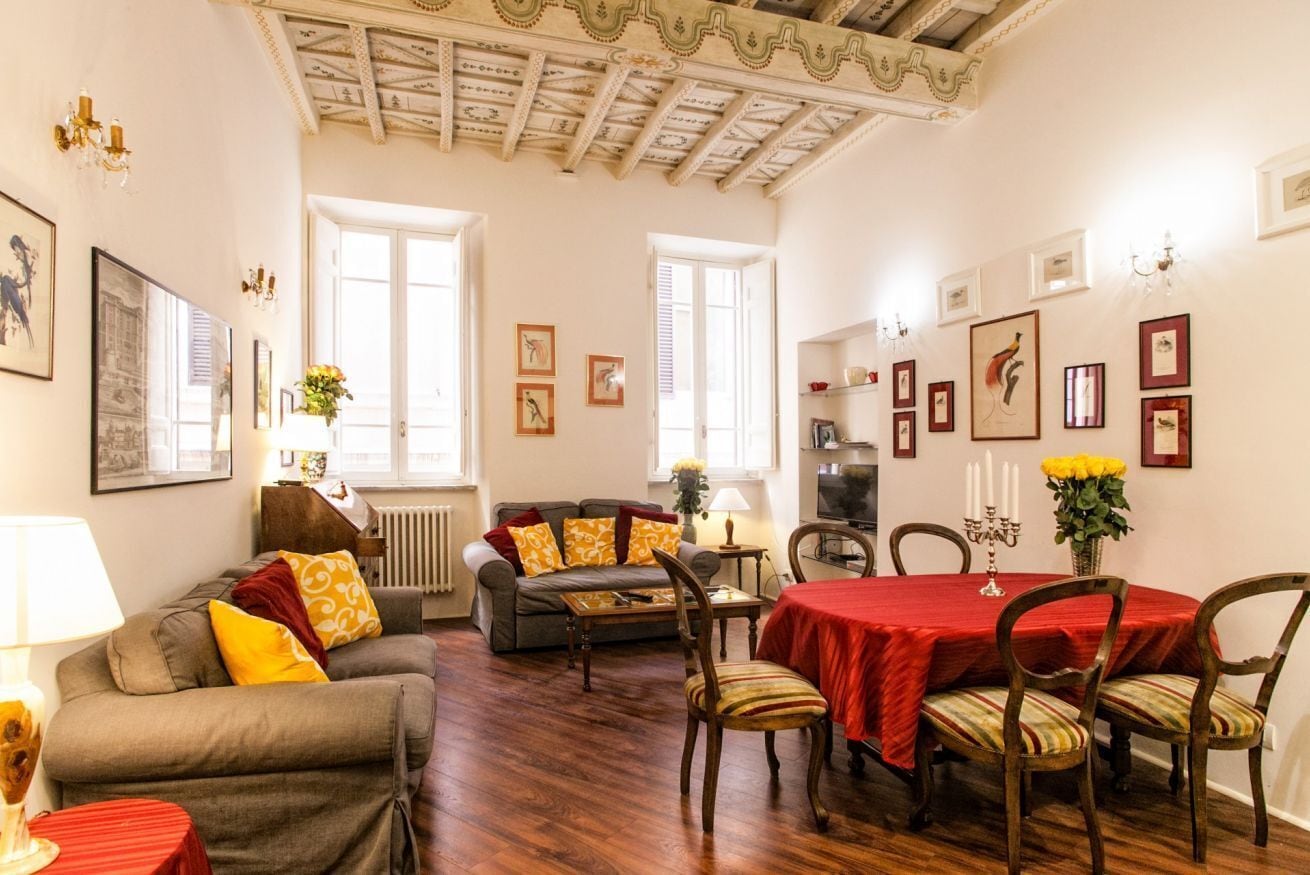 Ein gemütliches Wohnzimmer mit einer Couch, einem Esstisch mit Stühlen und einem Kamin.