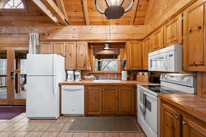 Fully equipped kitchen with refrigerator, coffee maker, microwave, and oven.