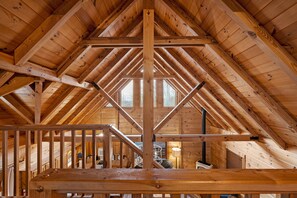 Cozy cabin with a high ceiling and open-plan layout featuring a staircase to the upper level.