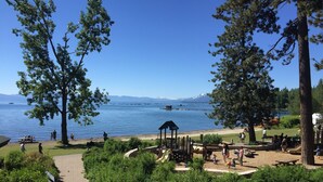 A park with a playground, picnic tables, and a bike path.