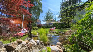 A serene garden with a pond, red foliage, and a wooden house. - Kneipp- und Wellvitalhotel Edelweiss (Bad Woerishofen)