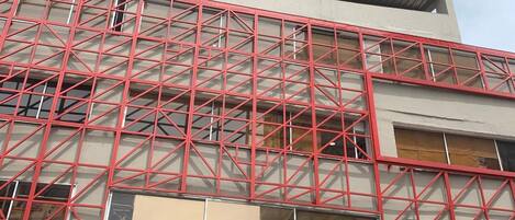 A multi-story building with a red metal framework.