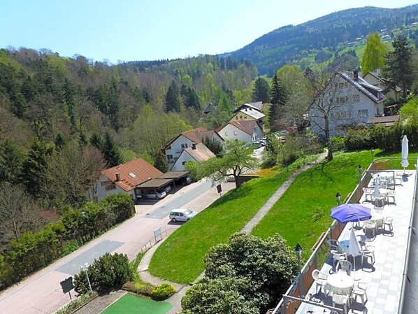 A residential area with houses, a paved road, and a green lawn.