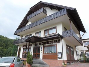 A multi-story hotel with balconies and a sign reading 'Hotel-restaurant Waldschlösschen.'