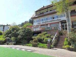 A two-story building with a cafe named 'Cafe Waldtröckchen' and a hotel named 'Hotel Pension.'