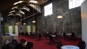 A spacious hall with high ceilings, multiple tables and chairs, and large windows allowing natural light. - Korpudalur (Flateyri)