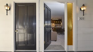 A hotel entrance with a dark wooden door, a number sign '305', and a glimpse of a kitchen area with hanging lights. - 305 Northgate at Silverado in Napa - One Bedroom Condo (Napa)