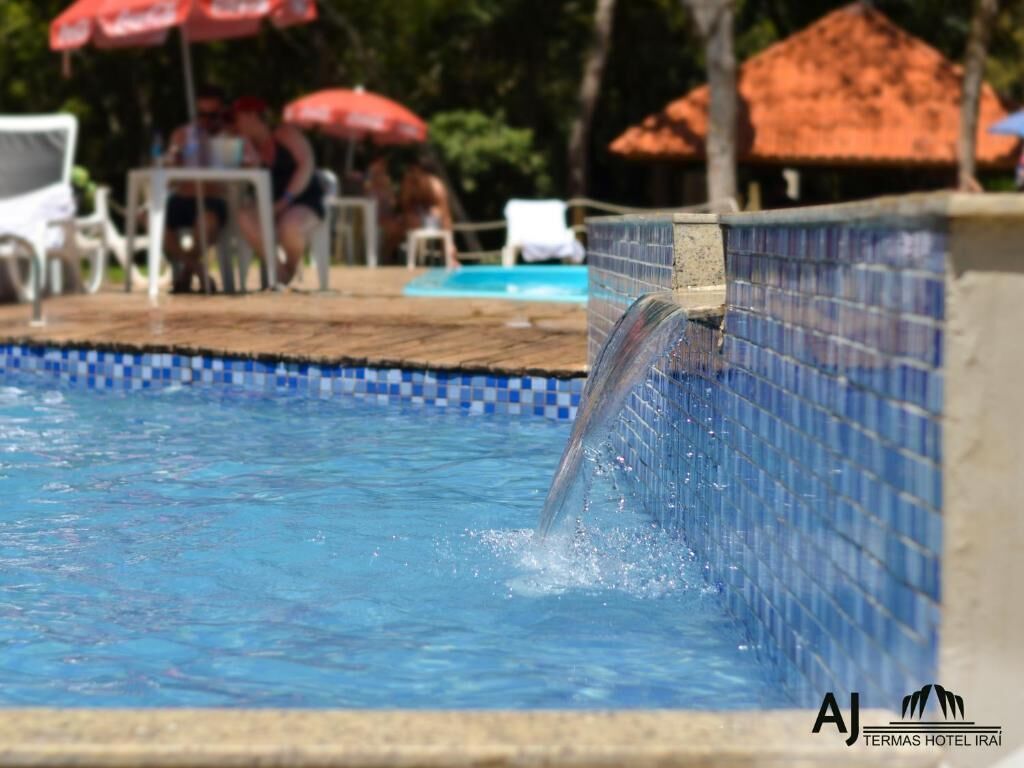 Une piscine dont le bord est revêtu de carreaux et dont l’eau est d’un bleu limpide.