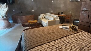 A modern bedroom with a large bed, a sofa, and a TV mounted on the wall. - Aj Termas Hotel Iraí (Irai)