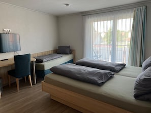 A room with a bed, a desk, and a chair.