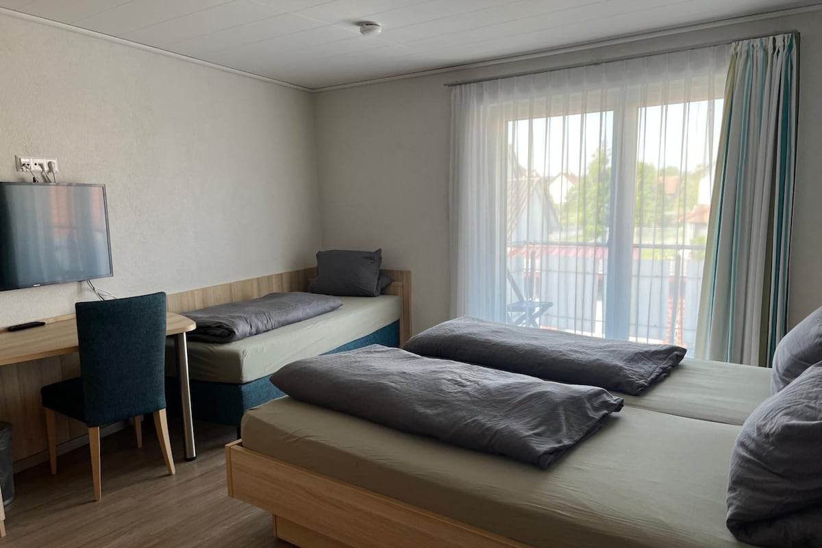 Quarto com uma cama, uma escrivaninha e uma cadeira.