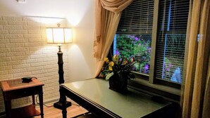A room with a wooden table, a lamp, a potted plant, and a window with curtains. - Stockbridge Lakes Bed & Breakfast (Stockbridge)
