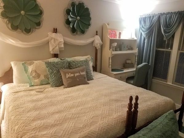 A neatly arranged bedroom with a bed, a bedside table, a chair, and decorative wall art. - Stockbridge Lakes Bed & Breakfast (Stockbridge)
