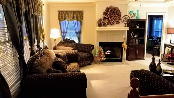 A living room with a fireplace, a sofa set, a lamp, and a bookshelf. - Stockbridge Lakes Bed & Breakfast (Stockbridge)