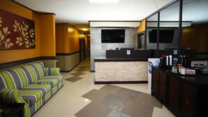 A hotel lobby with a reception desk, a striped sofa, and a large mirror. - Luxury Hotel & Apts (Georgetown)