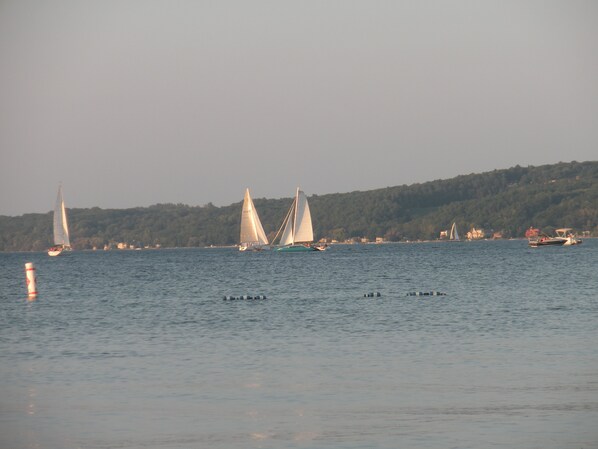 A calm body of water with sailboats and a few small boats.