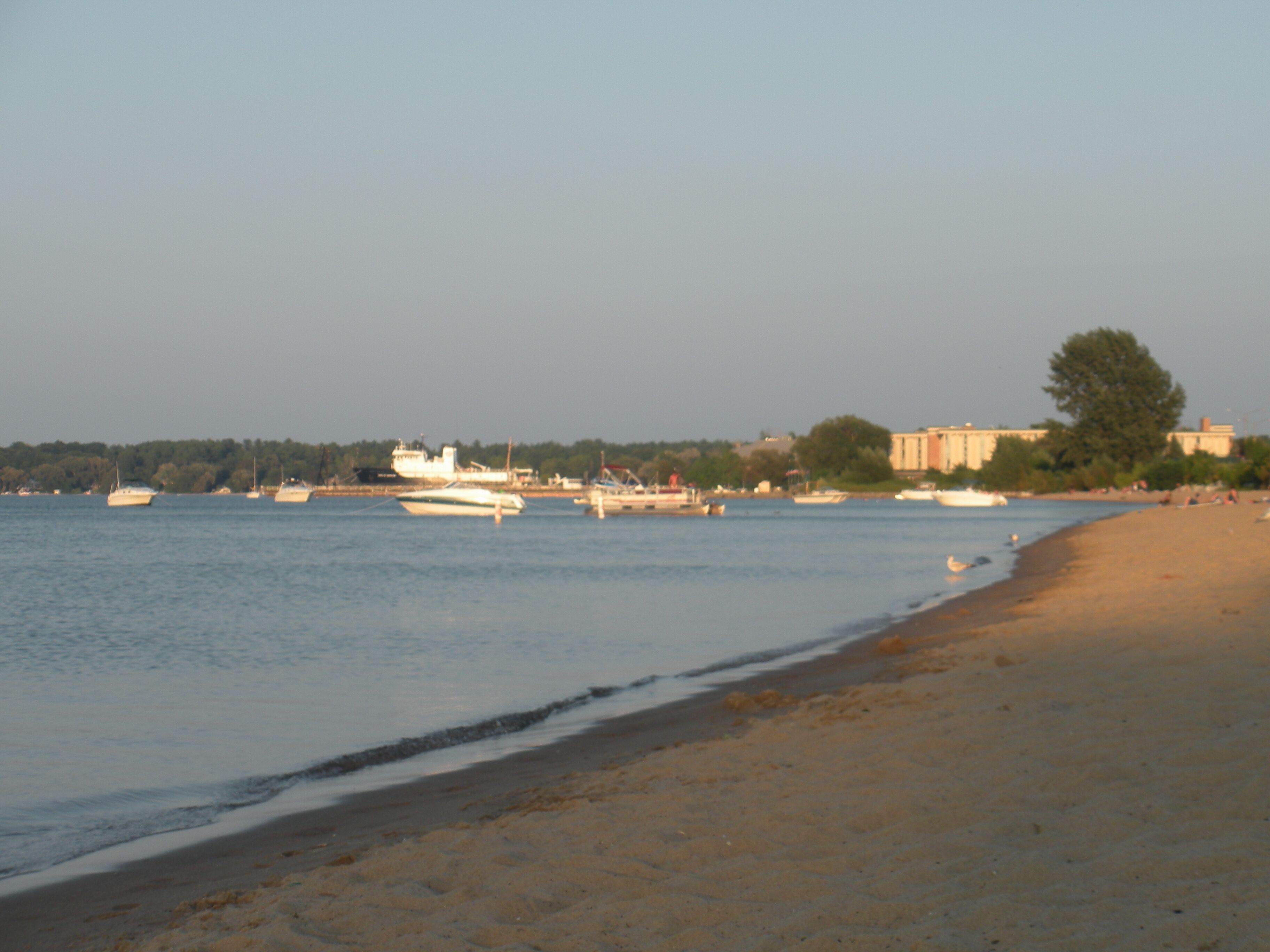 A beach with boats and a distant shoreline.