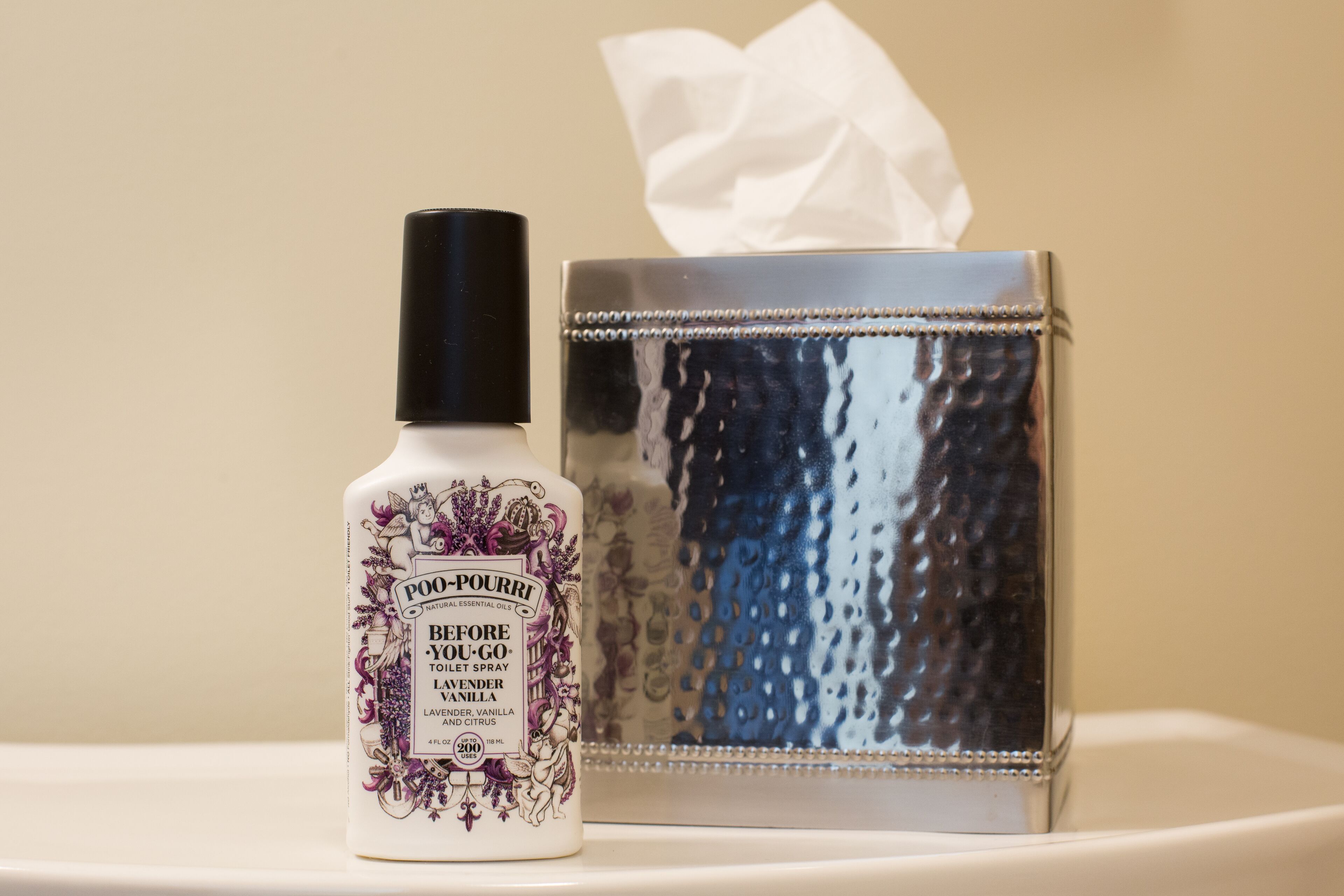 A bottle of Before You Go toilet spray next to a tissue box.