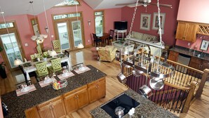 A spacious kitchen with granite countertops, wooden cabinets, and a central island with a sink. - Ocean View 6 Bedroom 4 Bath Home Cooled/Heated Pool No Typical Hidden Fees!! (Tybee Island)
