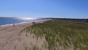 A beach with a grassy dune and a clear view of the ocean. - Your Summer Home - Close to Beach, Shops, Cafes, & Ferry! 50+ ⭐️⭐️⭐️⭐️⭐️ Reviews (Vineyard Haven)