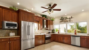 A spacious kitchen with wooden cabinets, stainless steel appliances, and a ceiling fan. - 5BR luxury home w/ pool, theater, rooftop deck & 100-ft dock near beach! (Marathon)