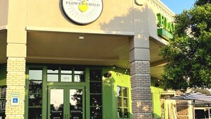 A building with a green facade, a sign reading "Flower Child," and a wheelchair-accessible parking sign. - Comfortable #Staycay Close to Everything In Dallas (Dallas)