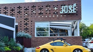 A building with a brick facade and a yellow sports car parked in front. - Comfortable #Staycay Close to Everything In Dallas (Dallas)