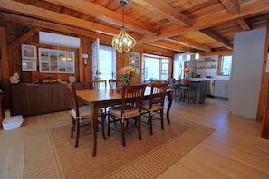 Un intérieur en bois comprenant un coin repas, une cuisine et un comptoir d’accueil.
