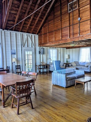Relax in this airy room with a large dining table, comfortable sofa, and ceiling fan for a refreshing stay.