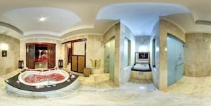 Relax in a spacious bathroom with a central hot tub and marble finishes.