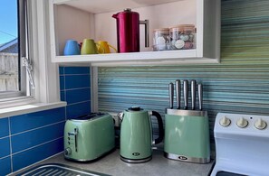A kitchen with a window, a toaster, a kettle, and a stove. - Riversong City Retreat - right on the edge of town (Nelson City)