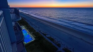 Et hotel ved stranden med pool og havudsigt.