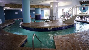 En indendørs swimmingpool med en dybdemarkering på 3 fod, et skilt med forbud mod forspring og et bassinområde med stole og borde.