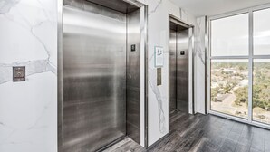 En moderne elevator med marmorvægge og frit udsyn ud af vinduet.