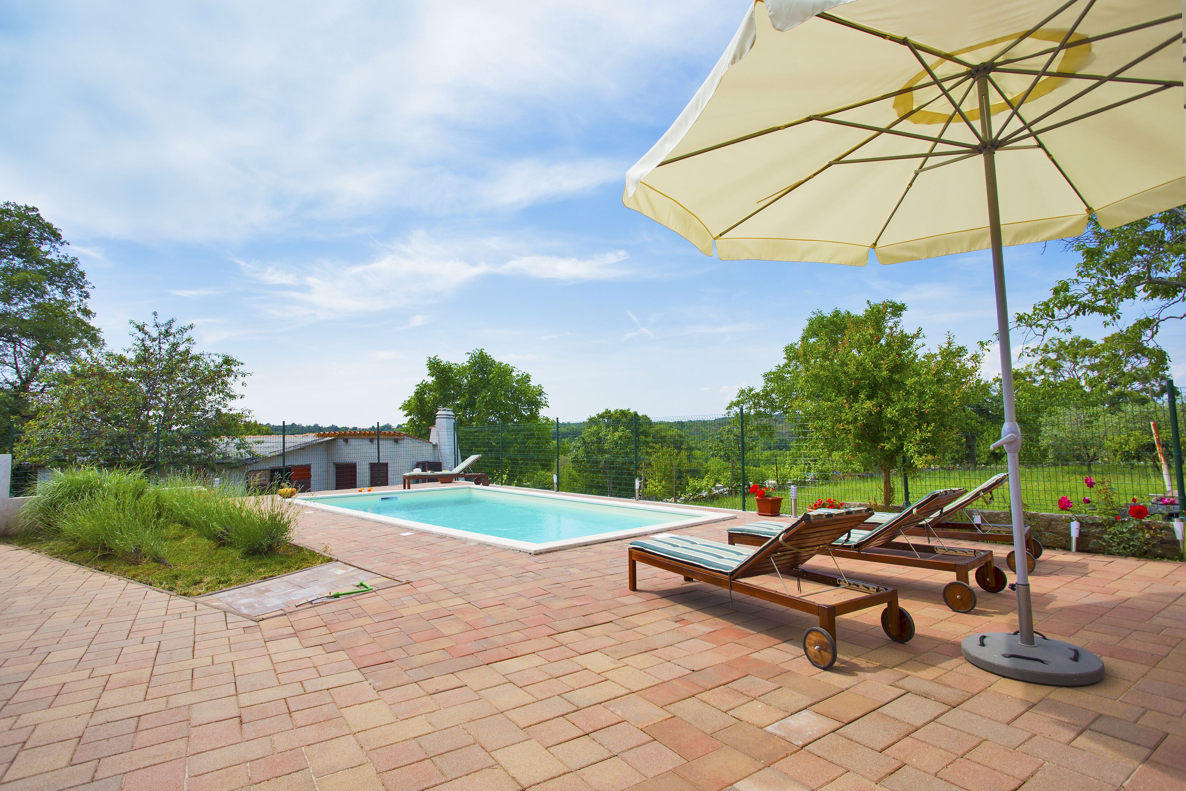 Ein Swimmingpool mit Liegestühlen und einem Sonnenschirm.