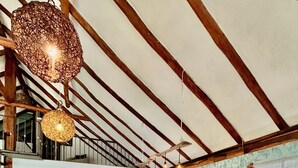Una cocina amplia con armarios de madera, un comedor con sillas blancas y una lámpara colgante.