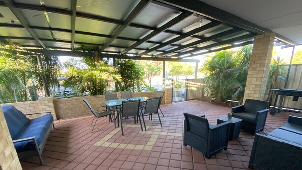 A covered patio area with tiled flooring, outdoor furniture, and potted plants. - Murchison Waters Accommodation (Kalbarri)