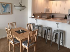Enjoy meals in the kitchen with a microwave and stainless steel range hood, and dine at the wooden table with comfortable seating for four.