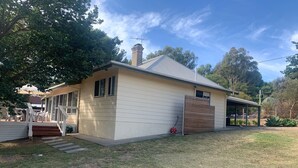 A single-story house with a covered porch, a fenced yard, and a small garden. - Port Willunga House on the Fleurieu Peninsula (Port Willunga)