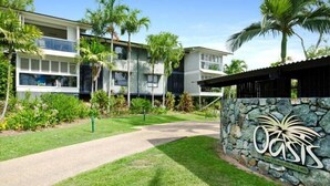 A modern two-story building with a stone wall entrance labeled "Oasis on Hamilton Two." - Oasis 23, Seaview Apartment on Hamilton Island (Hamilton Island)