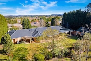 A residential property with a large house featuring a sloped roof, a covered porch, and a well-maintained lawn. - Sherwood Park - A rural atmosphere in town / set on 2 acres (Bowral)