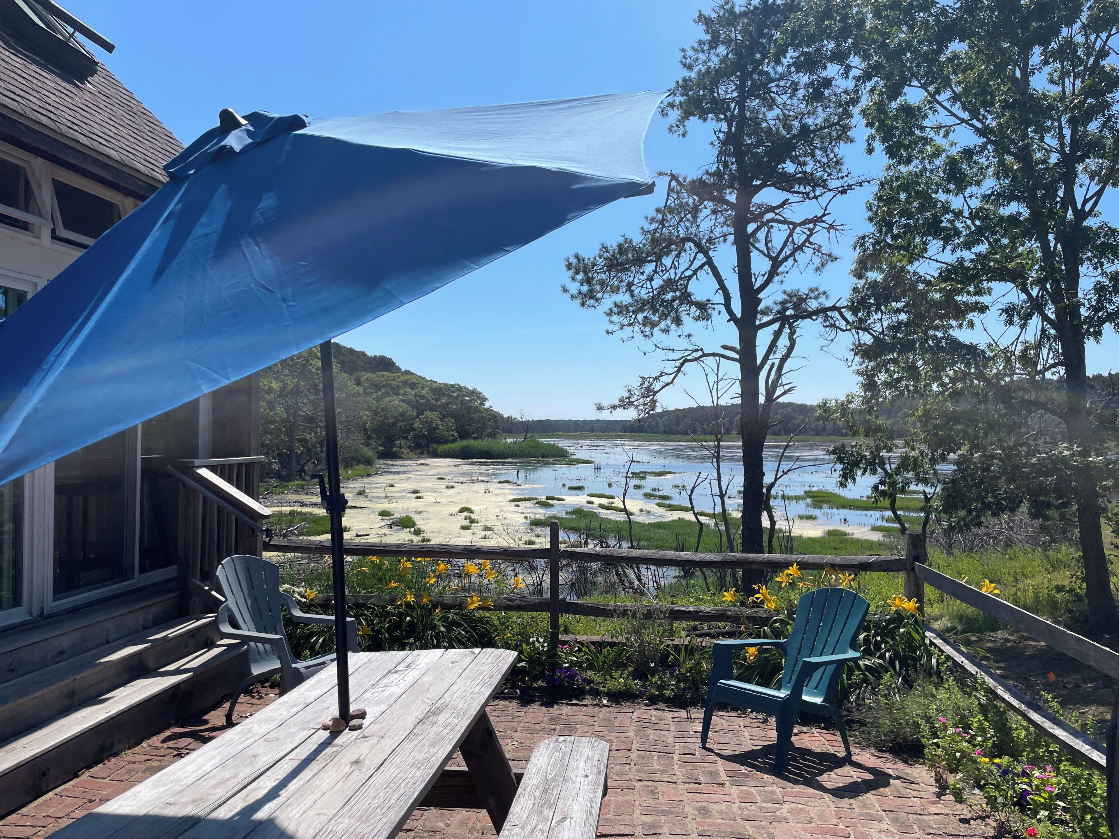 A patio with a view of a lake and trees.
