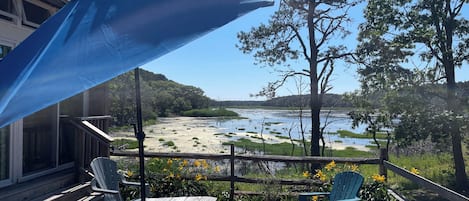 A patio with a view of a lake and trees.