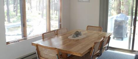 A dining area with a wooden table, six chairs, and a chandelier.