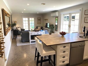 Una cocina moderna con una isla central, muebles blancos y lavavajillas.
