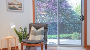 A modern living room with a leather armchair, a small side table with a lamp, and a potted plant. - ON THE TRAIL : Bright (Bright)