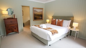 A hotel room with a bed, bedside lamps, a dresser, a painting, and a carpeted floor. - ON THE TRAIL : Bright (Bright)