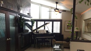 A living room with a grand piano, a glass coffee table, and a sofa. - Experience a Relaxing Retreat at Lookout Mountain Lodge (30 Day Min) (Golden)