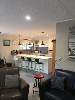 A modern kitchen with a central island, bar stools, and pendant lighting. - Corkwood at Smiths Lake - 3 bedroom pet friendly (Smiths Lake)